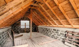 Drewniana konstrukcja poddasza, ściany z bloczków, deski na podłodze. Trwają prace nad tym, jak zabudować wejście na strych.