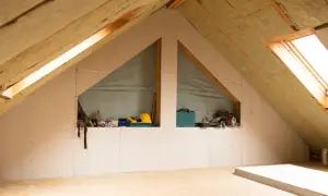 Poddasze nieużytkowe w trakcie adaptacji. Widoczne płyty gipsowo-kartonowe, wełna mineralna i narzędzia budowlane. Pomysł na to, jak zagospodarować poddasze nieużytkowe.