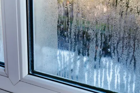 Krople wody na szybie okna, wyjaśniające, dlaczego skrapla się woda na oknach.