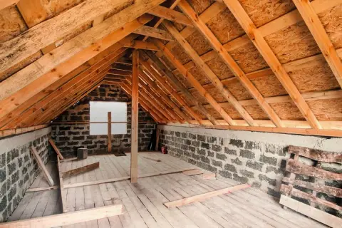 Drewniana konstrukcja poddasza, ściany z bloczków, deski na podłodze. Trwają prace nad tym, jak zabudować wejście na strych.