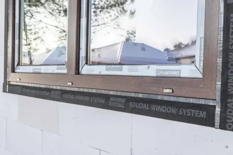 Szpaleta okienna to warstwa izolacyjna wokół okna, widoczna na styku ramy okiennej z murem z bloczków.