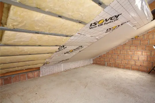Montaż stelaża pod regipsy na poddaszu: wełna mineralna, folia paroizolacyjna i profile stalowe tworzą konstrukcję.