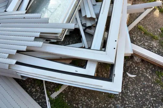 Stare okna plastikowe czekają na recykling. Czy okna plastikowe nadają się do recyklingu? Tak, można je przetworzyć.