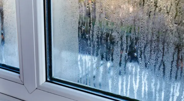 Krople wody na szybie okna, wyjaśniające, dlaczego skrapla się woda na oknach.