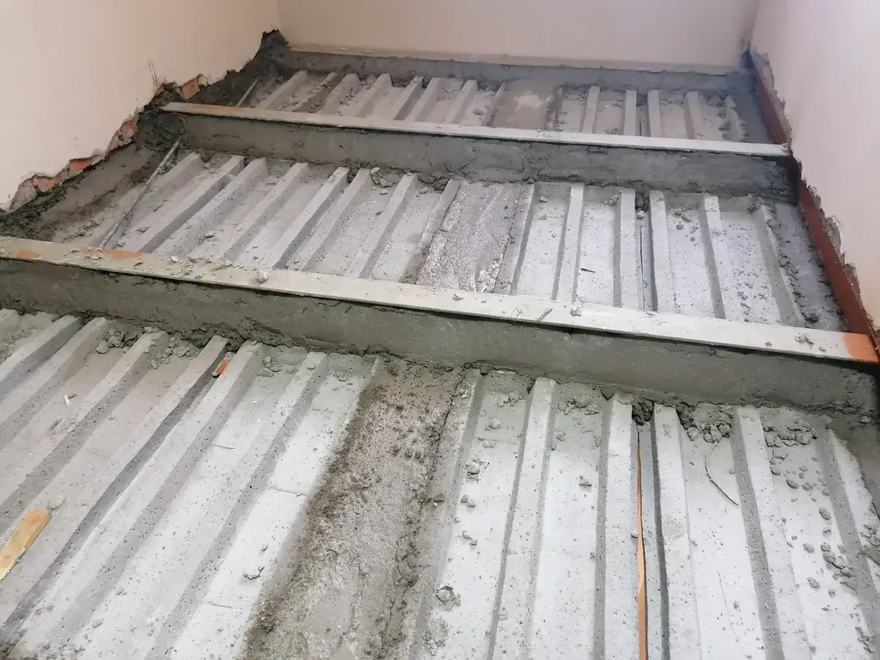 Prace budowlane: betonowe belki stropowe zbrojone stalą, przygotowanie do prac, jak wzmocnić strop.