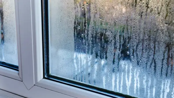 Krople wody na szybie okna, wyjaśniające, dlaczego skrapla się woda na oknach.